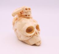 A carved bone netsuke formed as a skull. 4 cm high.