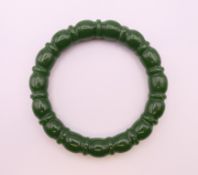 A carved jade bangle. 5.5 cm internal diameter.