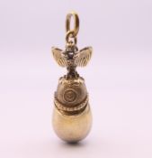 A silver gilt egg and helmet pendant. 4 cm high.