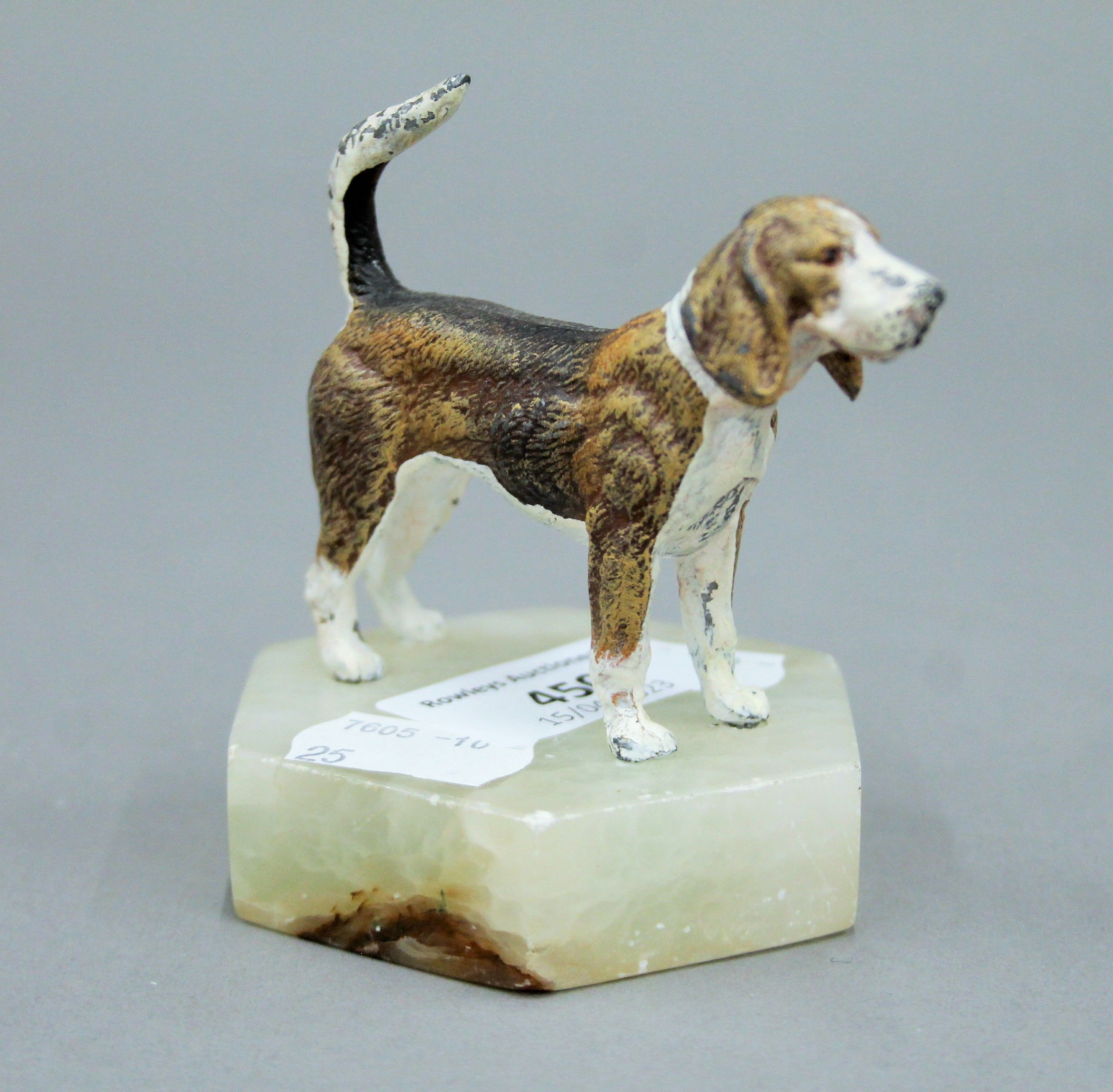 A cold painted white metal model of a beagle on a plinth base. 8 cm high overall.