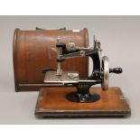 A miniature 'LEAD' sewing machine and case. The case 23 cm long.
