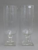 A pair of glass storm lamps. 40 cm high.