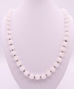 A white jade bead necklace. Approximately 70 cm long.