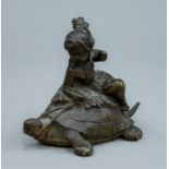 A bronze model of a child riding a tortoise. 8 cm high.