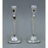 A pair of George V silver candlesticks, on a square base, hallmarked for Chester 1915. 26 cm high.