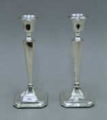 A pair of George V silver candlesticks, on a square base, hallmarked for Chester 1915. 26 cm high.