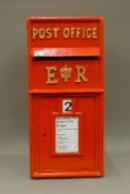 A red post box. 64.5 cm high.