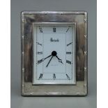 A silver Harrods clock. 9 cm wide.