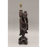 A late 19th/early 20th century Oriental carved wooden figural lamp. 58 cm high overall.