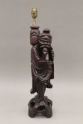 A late 19th/early 20th century Oriental carved wooden figural lamp. 58 cm high overall.