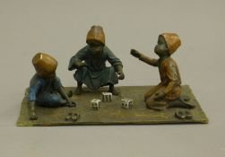A cold painted bronze model of boys playing dice. 20 cm wide.