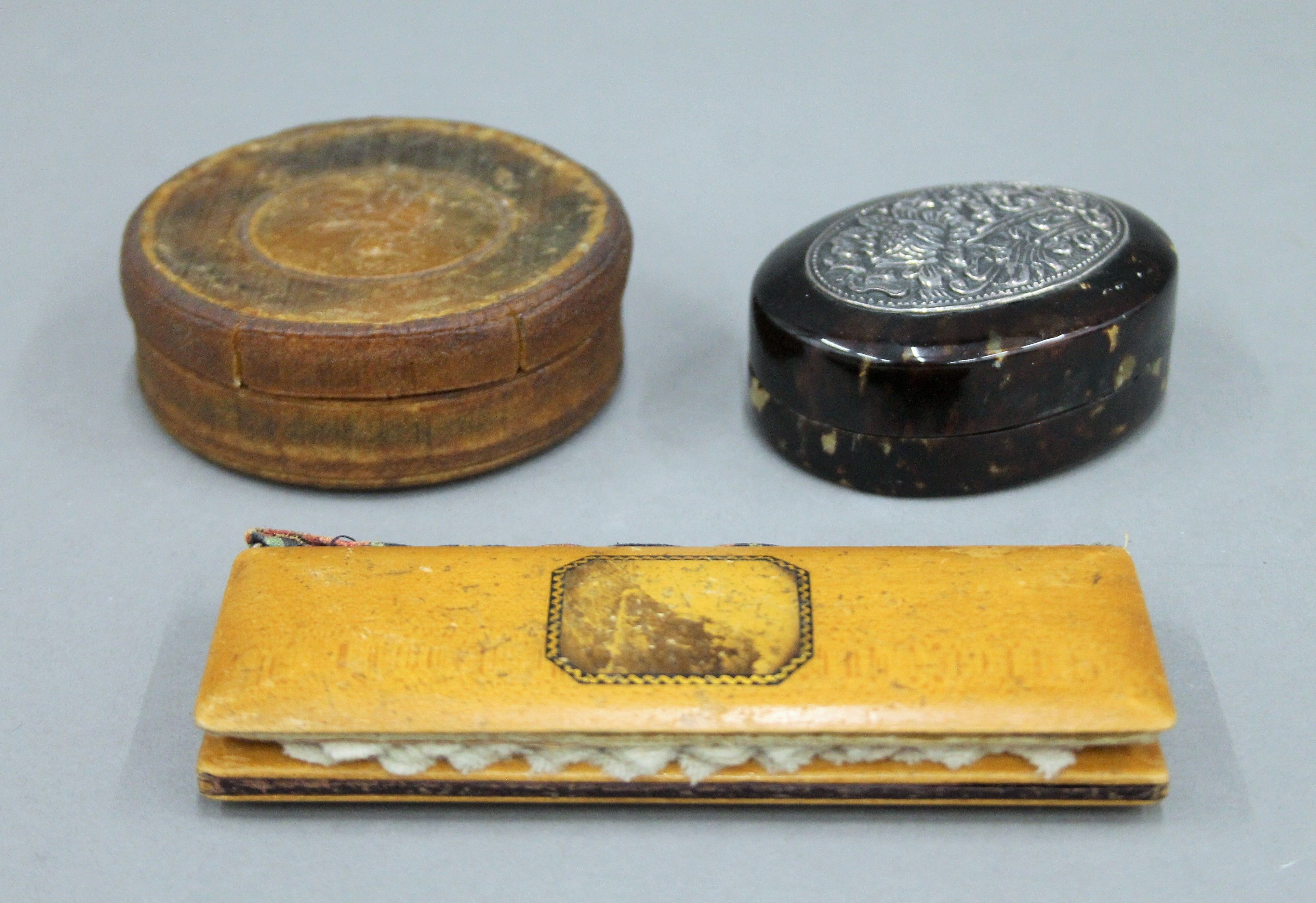 Two snuff boxes and a mauchline ware needle case.