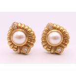 A pair of 18 K gold pearl and diamond earrings. 16.5 grammes total weight.