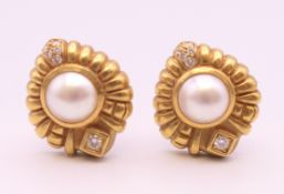 A pair of 18 K gold pearl and diamond earrings. 16.5 grammes total weight.