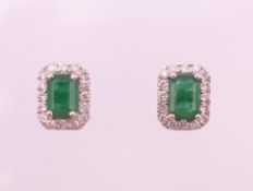 A pair of 18 ct white gold rectangular emerald and diamond stud earrings. 9 mm high.