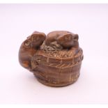 A wooden netsuke formed as rats on a barrel. 3 cm high.