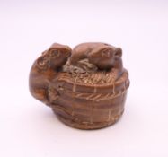 A wooden netsuke formed as rats on a barrel. 3 cm high.