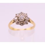 An 18 ct gold diamond flowerhead ring. Ring size M. 2.4 grammes total weight.