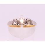 An 18 ct gold three and platinum stone diamond ring. Ring size N. 2.7 grammes total weight.
