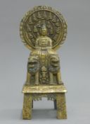 A gilt bronze model of Buddha seated on two dogs-of-fo. 27 cm high.