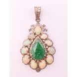 A silver opal, emerald and diamond set pendant. 5 cm high including suspension loop.