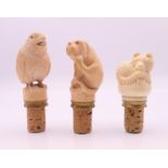 Three bottle stoppers. The largest approximately 9 cm high overall.
