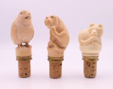 Three bottle stoppers. The largest approximately 9 cm high overall.