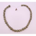 A carved jade necklace. Approximately 48 cm long.