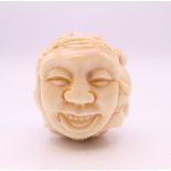 A bone carving formed as faces. 3.5 cm high.