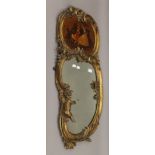 A 19th century gilt framed wall glass with painted panel. 95 cm high.
