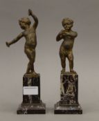 A pair of bronze putto, on marble bases. The largest 27 cm high.