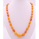 A string of vintage butterscotch amber graduated beads. Approximately 64 cm long.
