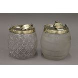 Two silver plated mounted glass biscuit barrels. The largest 18 cm high.