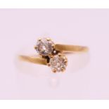 An 18 ct gold diamond two stone cross over ring. Total diamond weight approximately 0.25 carat.