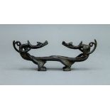 An 18th/19th century bronze entwined dragon form brush rest. 17 cm long.