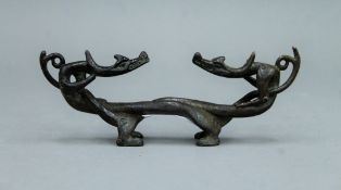 An 18th/19th century bronze entwined dragon form brush rest. 17 cm long.