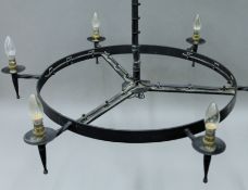 A circular black painted metal chandelier. Approximately 90 cm diameter.