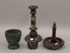 Four various carved Serpentine items, including a candlestick. The latter 24 cm high.