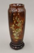 A 19th century Japanese turned wooden lacquered vase with mother-of-pearl inlay on a wooden stand