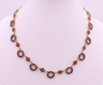 A silver gilt garnet necklace. 36 cm long.