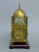 A brass lantern clock. 32 cm high.