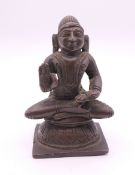 A small Indian bronze model of a deity. 7 cm high.