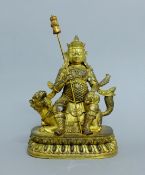 A Chinese gilt bronze model of a deity on a dog-of-fo. 26.5 cm high.