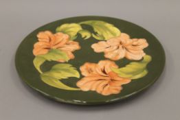 A Moorcroft Hibiscus pattern charger. 31 cm diameter.