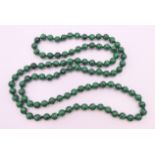 A string of malachite beads. Approximately 88 cm long.
