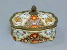 A bronze and porcelain lidded box. 16 cm long.