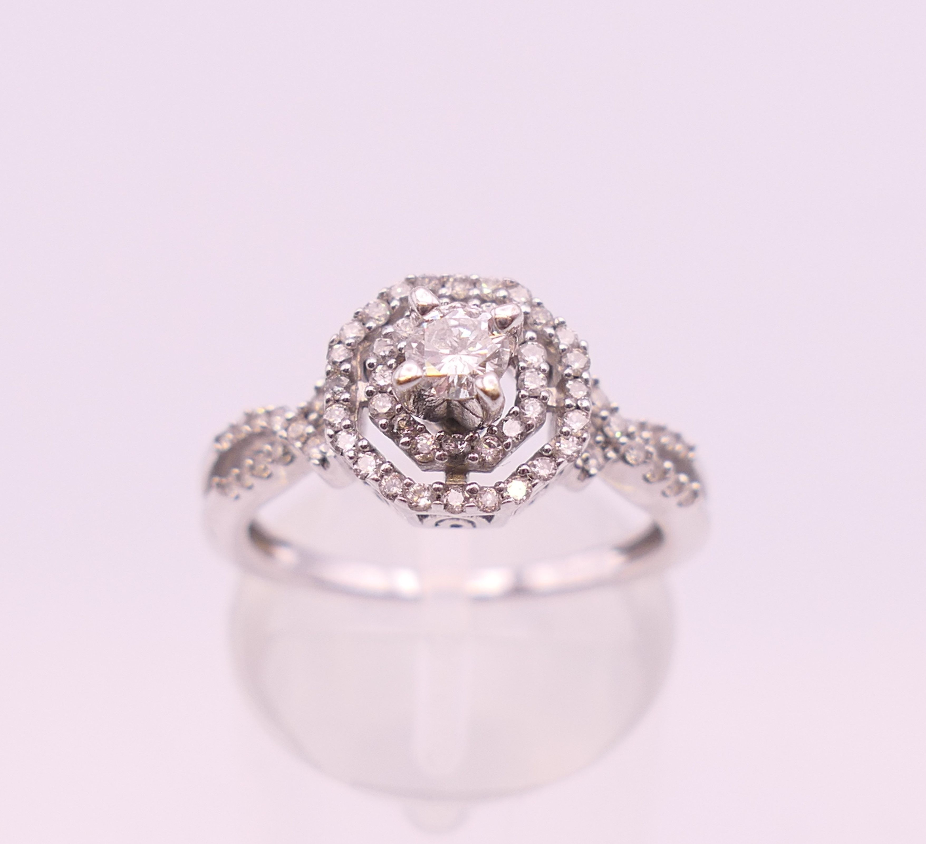 A 14 K white gold diamond ring. Ring size L/M. 3.6 grammes total weight.
