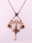 A 9 ct gold Art Nouveau amethyst and seed pearl set pendant on chain. The pendant 3.25 cm high. 5.