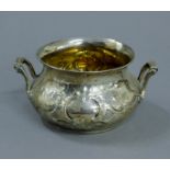 An embossed silver sugar bowl. 16.5 cm wide. 9.6 troy ounces.