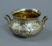 An embossed silver sugar bowl. 16.5 cm wide. 9.6 troy ounces.
